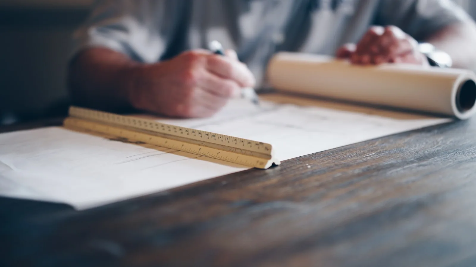 Architectural blueprint with hard hat and drafting tools