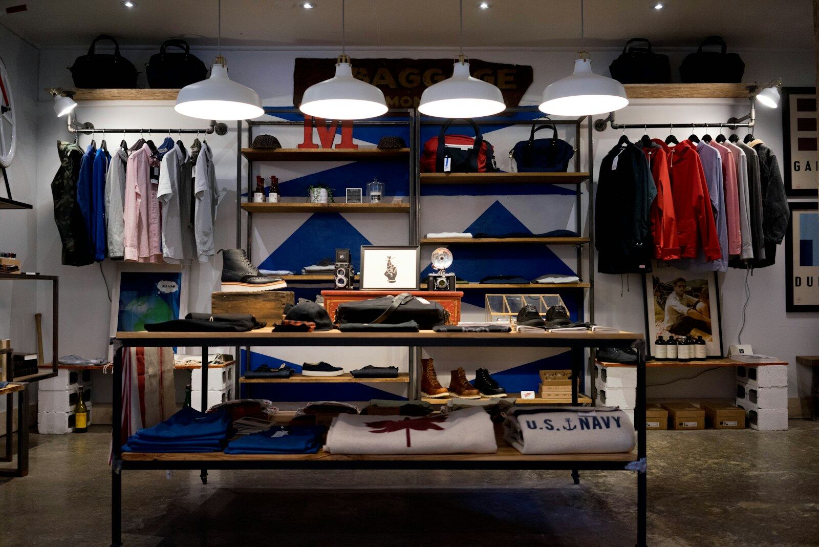 Menswear boutique with rails, shelving and warm pendant lighting