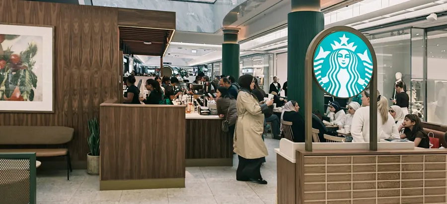 Starbucks siren sign, walnut-clad counter enclosure and customer seating area
